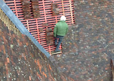 Image of team working on clay tile roof restoration, Surrey.